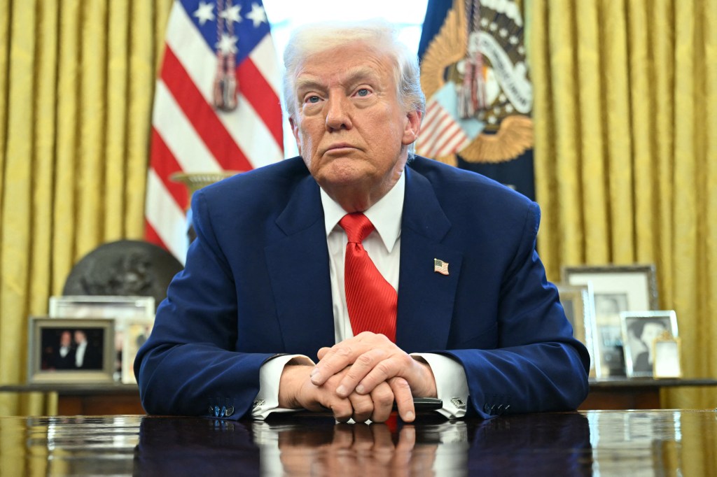 President Donald Trump sitting on his table at the Oval Office.