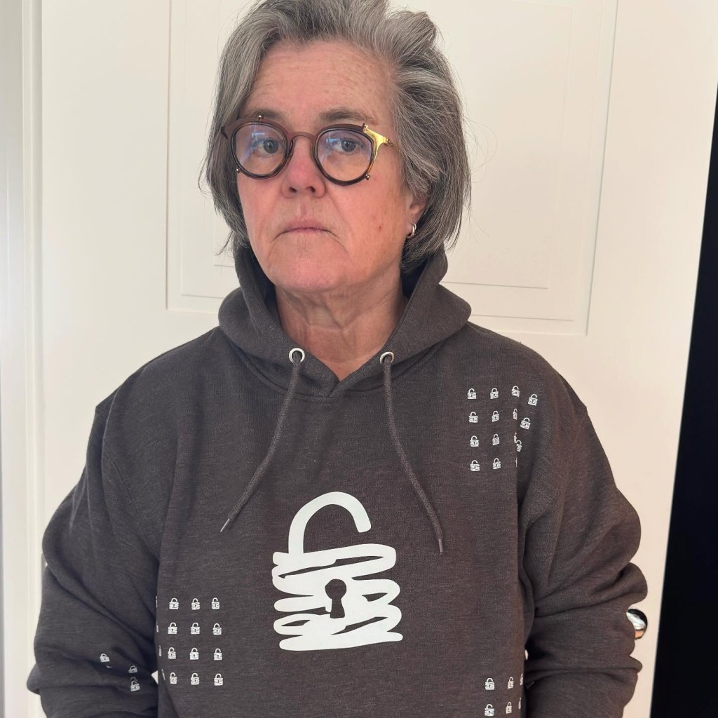 Rosie O'Donnell dressed in a dark gray hood with a graph of an unlocked box.